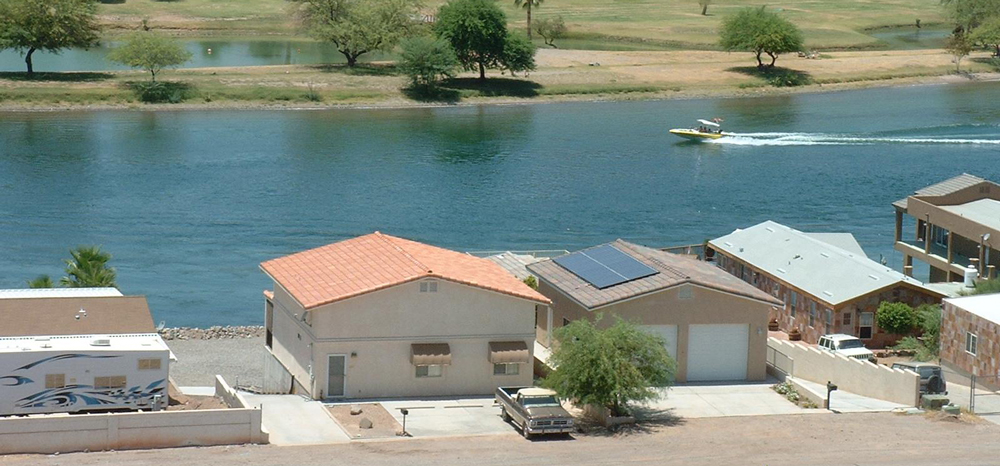 row of homes with solar power next to water