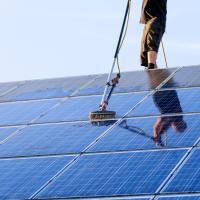 Cleaning solar panel with brush and water