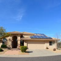 house with solar panels with driveway and cactus