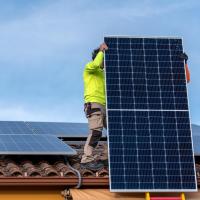 man on roof installing solar panels