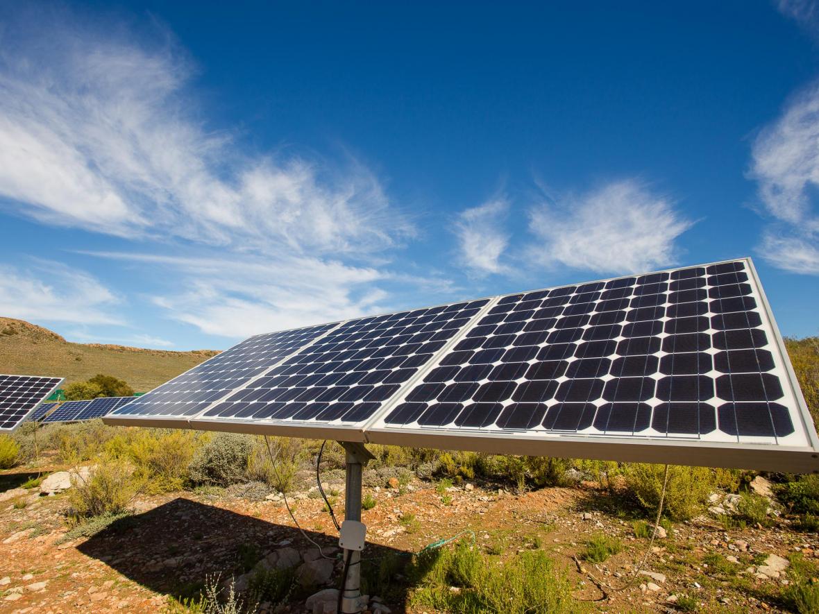 Solar panel in field with mountains in background