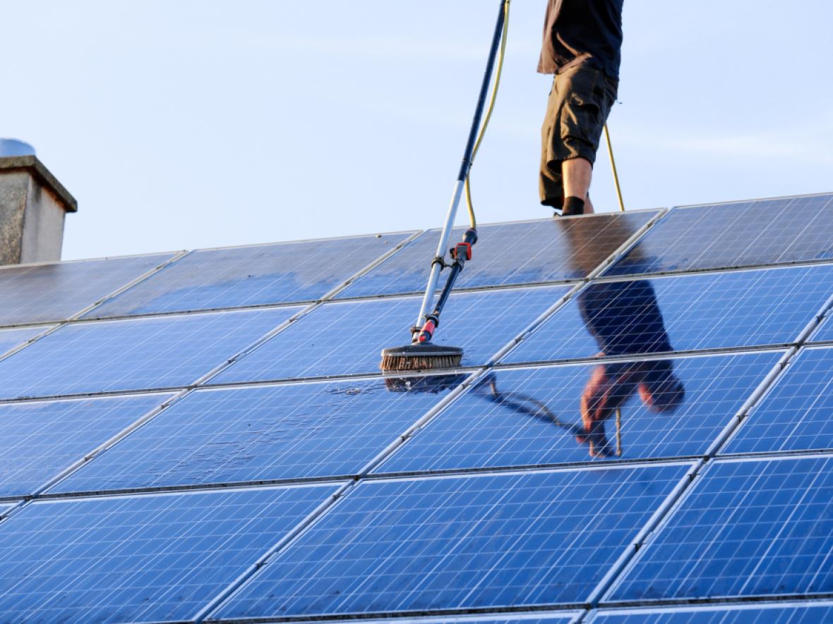 Cleaning solar panel with brush and water