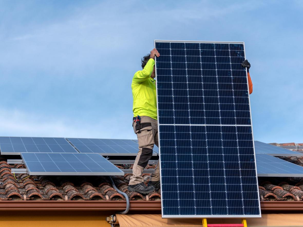 man on roof installing solar panels
