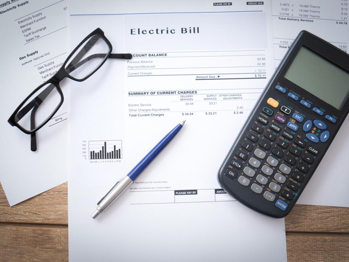 electric bill with calculator, pen and glasses