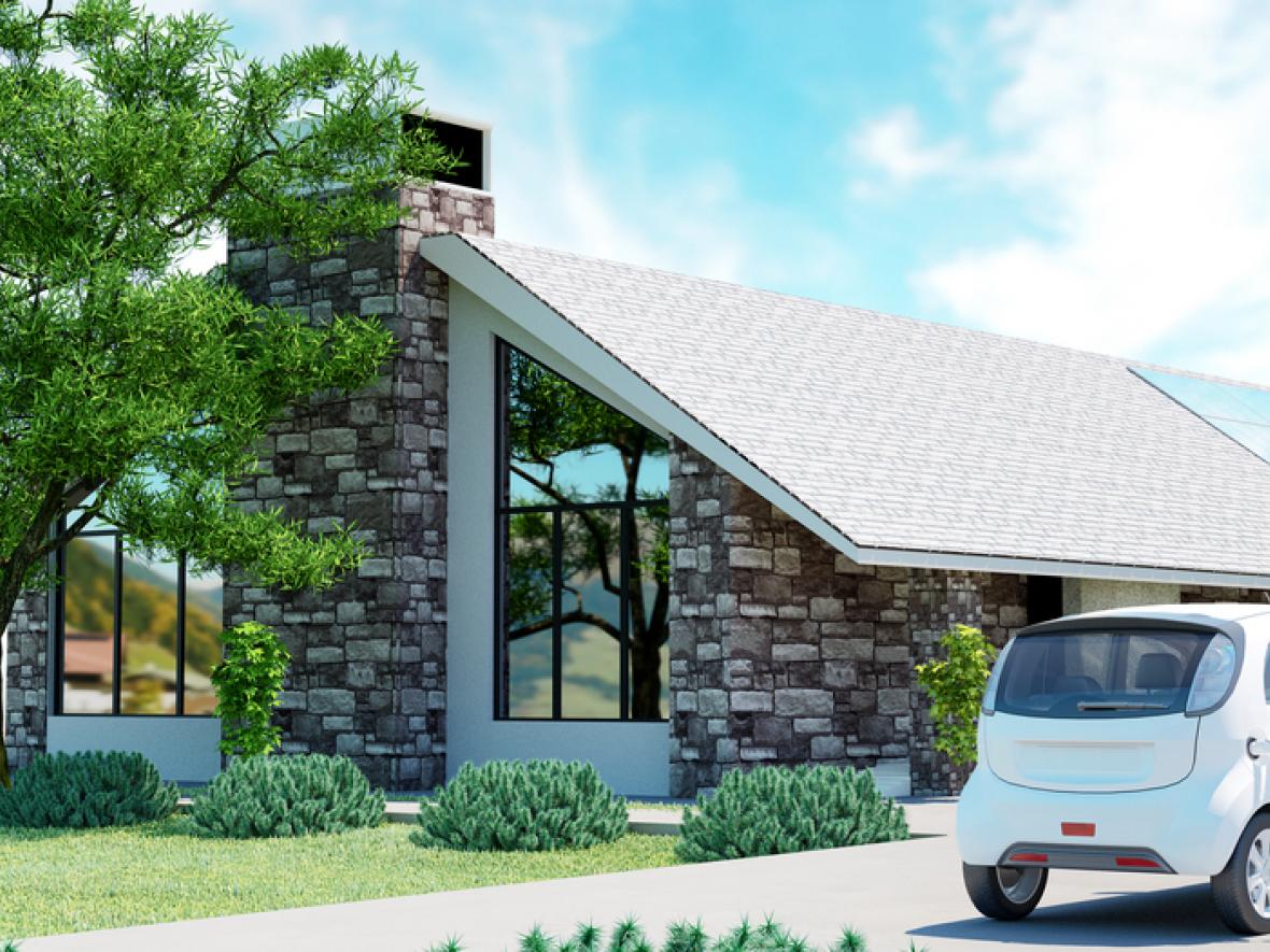 house with solar panels and electric car