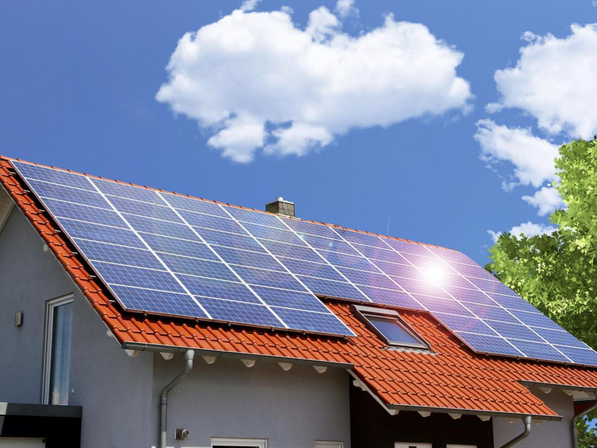 solar panels on roof with clouds in sky