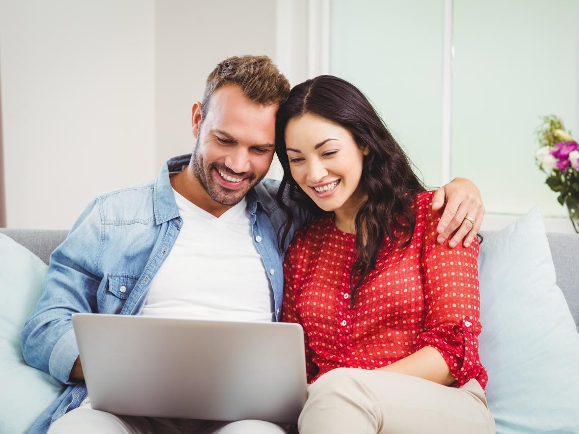 man and woman on looking on laptop together