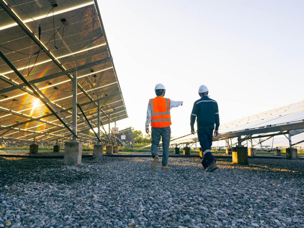two men walking by commercial solar panels