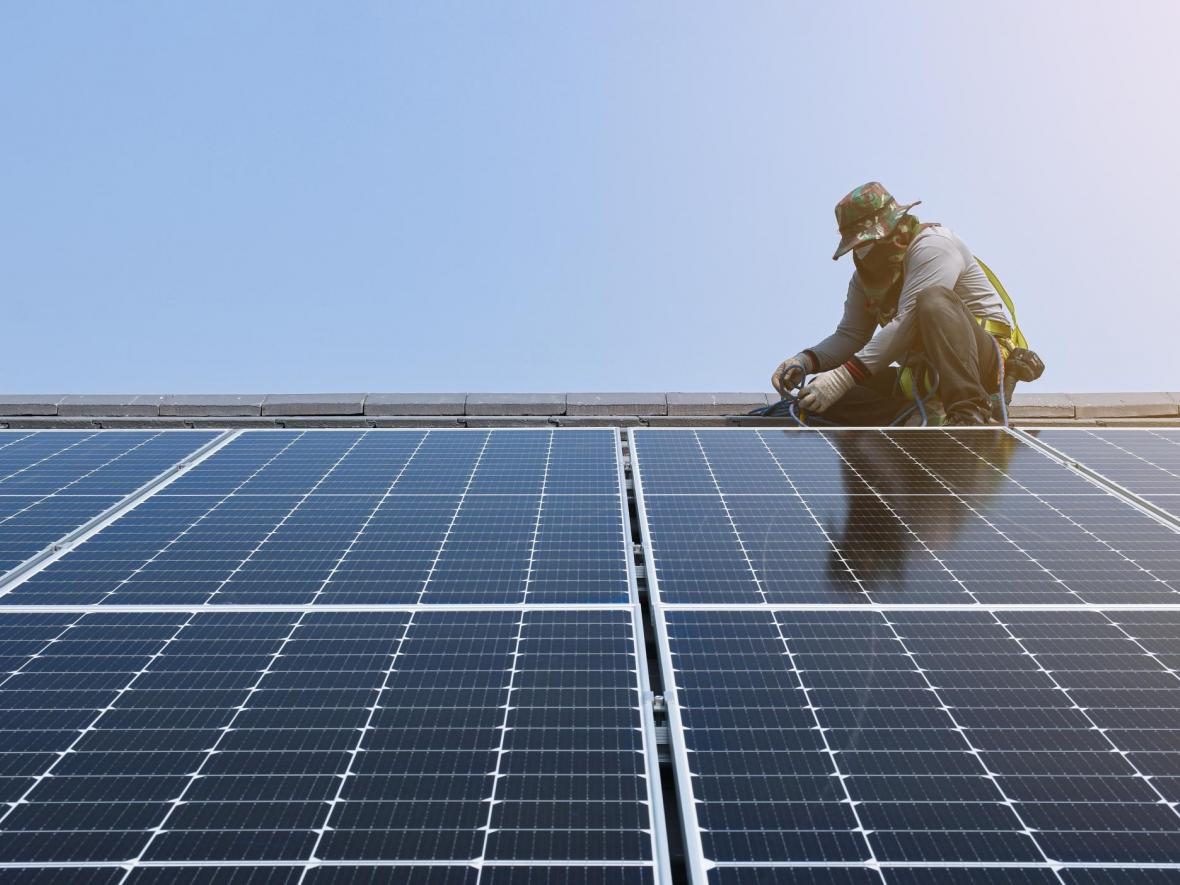 man on roof fixing solar panels